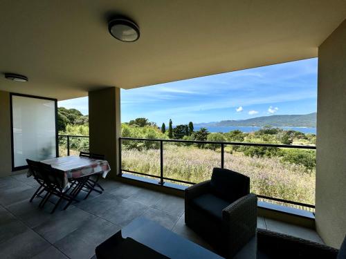 普罗普里亚诺T2 neuf vue mer proximite plage的带桌椅和大窗户的客厅