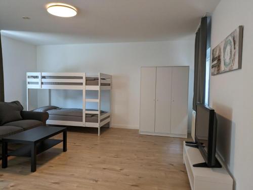 a living room with a couch and a tv and a bunk bed at interaktiv Appartements in Ratingen - Düsseldorferstrasse in Ratingen