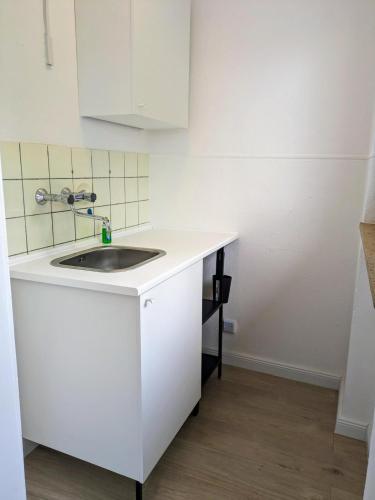 a kitchen with a sink and a white cabinet at interaktiv Appartements in Ratingen - Düsseldorferstrasse in Ratingen