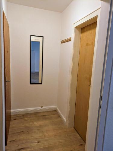 a hallway with a door and a mirror on a wall at interaktiv Appartements in Ratingen - Düsseldorferstrasse in Ratingen