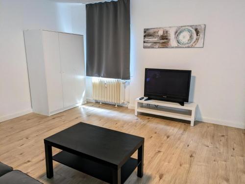 a living room with a tv and a coffee table at interaktiv Appartements in Ratingen - Düsseldorferstrasse in Ratingen