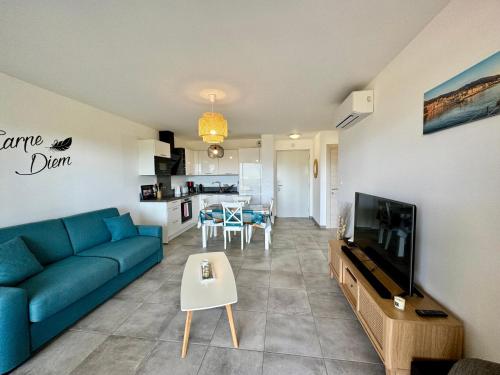 普罗普里亚诺T2 neuf vue mer proximite plage的客厅里有一张蓝色沙发和一台电视