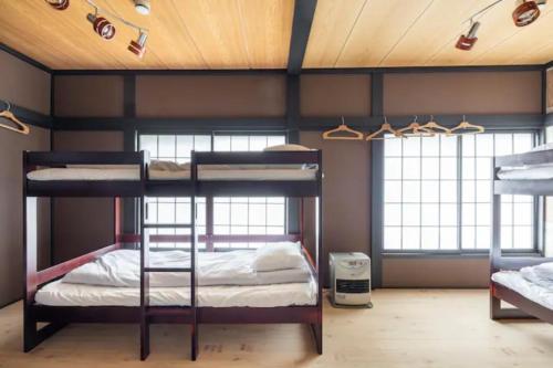 2 łóżka piętrowe w pokoju z oknami w obiekcie The HOTEL YUZAWA STARDUST w mieście Yuzawa