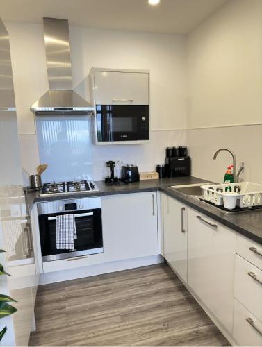a kitchen with white cabinets and a stove at JayGees luxury homes in Lower Gornal