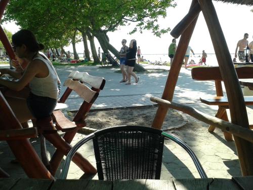 a woman sitting in a chair at a playground at Munkácsy Apartmanok in Balatonfenyves