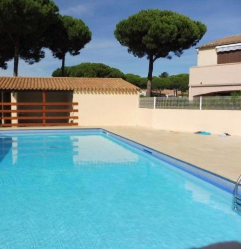 une grande piscine bleue avec des arbres en arrière-plan dans l'établissement lililoucap, au Cap d'Agde