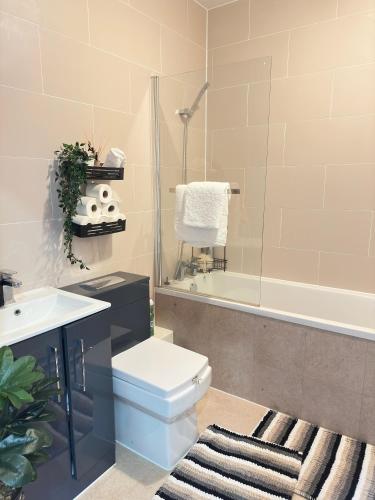 a bathroom with a toilet and a sink and a tub at JayGees luxury homes in Lower Gornal
