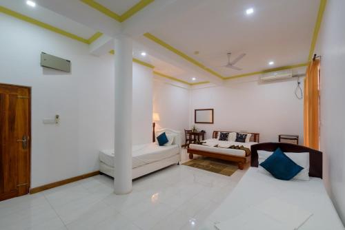 a living room with two beds and a couch at Hotel Sobana Lake front in Udawalawe