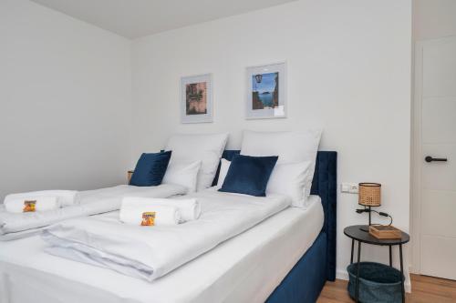 a white couch with blue pillows on it at Villa Laganini Apartment 2&4 in Podaca