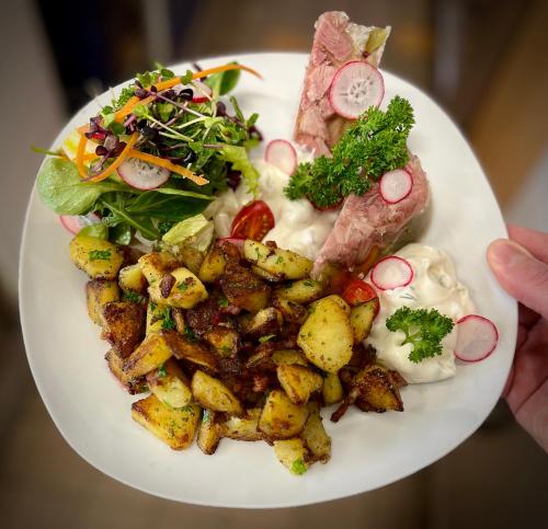 a plate of food with meat potatoes and a salad at Traditionsgasthaus Goldener Löwe Riesa Restaurant & Pension in Riesa