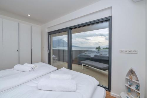 a white bedroom with a view of the ocean at Villa Laganini Apartment 2&4 in Podaca