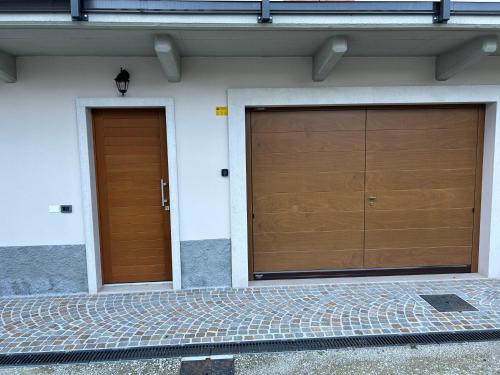 two brown garage doors on the side of a building at Appartamento CS in Sabbionara