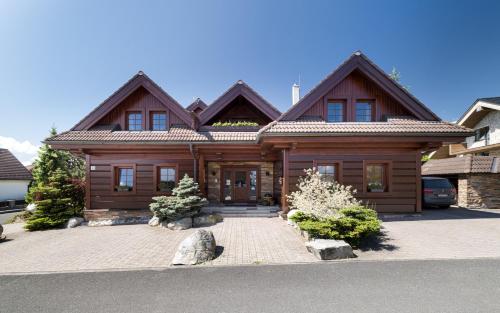 a wooden house with a car parked in front of it at Vila GRAND in Smokovce