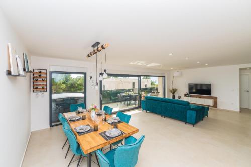 a dining room and living room with a table and chairs at Villa Laganini Apartment 2&4 in Podaca
