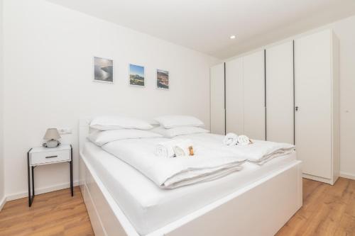 a white bedroom with a large white bed at Villa Laganini Apartment 2&4 in Podaca