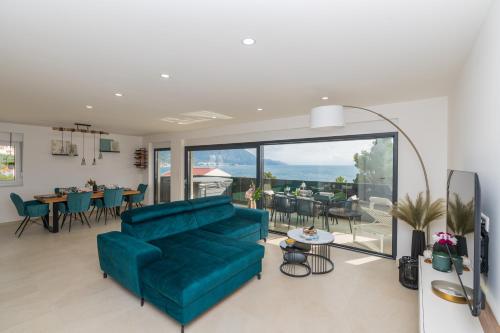 a living room with a blue couch and a table at Villa Laganini Apartment 2&4 in Podaca
