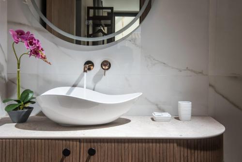a bathroom with a white sink and a mirror at VAYA Suites by Omilos Hotels in Amoudara Herakliou
