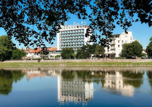 Reflexion eines Gebäudes in einem Wasserkörper in der Unterkunft Hotel Magnólia in Piešťany