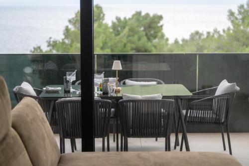 a table and chairs with a green table and a window at Villa Laganini Apartment 2&4 in Podaca