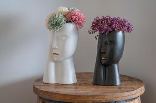 two black and white vases with flowers on a table at Villa Laganini Apartment 2&4 in Podaca