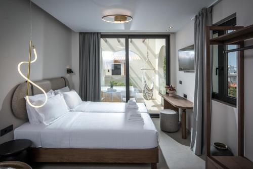 a hotel room with a bed and a balcony at VAYA Suites by Omilos Hotels in Amoudara Herakliou