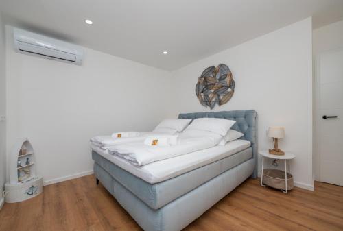 a white bedroom with a bed with white pillows at Villa Laganini Apartment 2&4 in Podaca