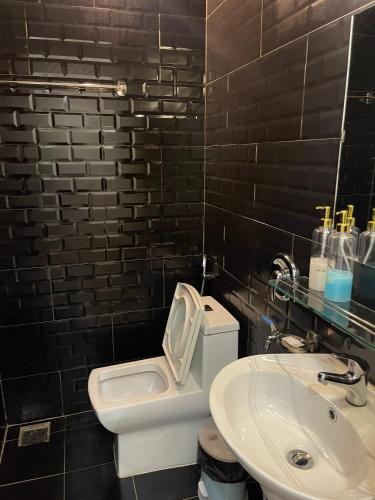 a bathroom with a white toilet and a sink at ROSE HOSTEL DALAT in Da Lat
