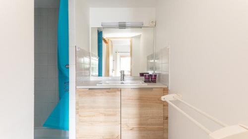 une salle de bain avec un lavabo et un miroir dans l'établissement Les Ondines 2- 29- Maison charme- 6 pers, au Cap d'Agde