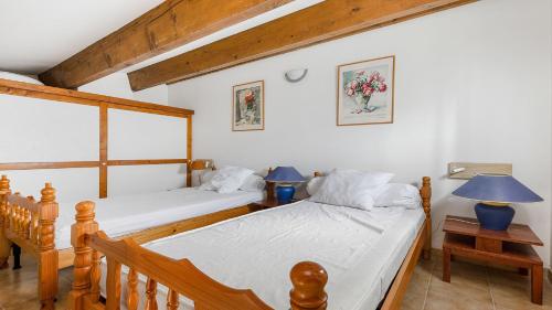 - une chambre avec 2 lits et 2 lampes sur les tables dans l'établissement Les Ondines 2- 29- Maison charme- 6 pers, au Cap d'Agde