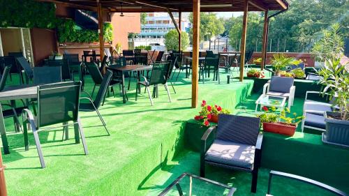 an outdoor patio with chairs and tables and plants at BSA Gradina Hotel & Aquapark - All Inclusive in Golden Sands
