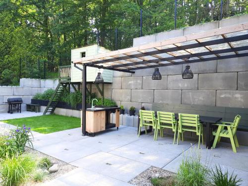 a patio with a table and chairs under a pergola at Dom nad Jeziorem Bory Tucholskie Pomost Łódka in Cierplewo