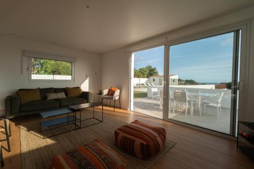 a living room with a couch and a table and a balcony at Casa da Bela Vista (Piscina e Vista Mar) in Ponta Delgada