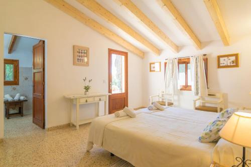 ein Schlafzimmer mit großem Bett und Schreibtisch in der Unterkunft Can Ferrer in Pollença