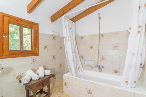ein Bad mit einer Badewanne und einem Fenster in der Unterkunft Can Ferrer in Pollença