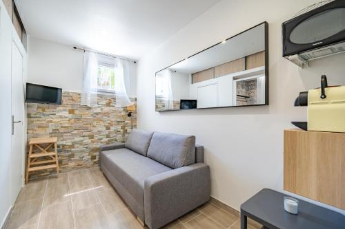 un salon avec un canapé et une télévision dans l'établissement Port de Nice, Charmant studio, à Nice