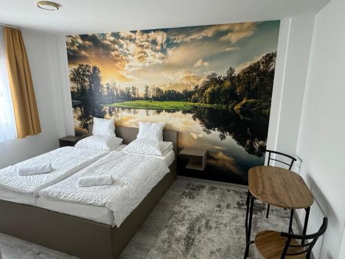 a bedroom with a painting of a river at Pótkerék Motel in Győr