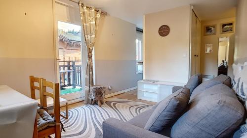 un salon avec un canapé et une fenêtre dans l'établissement Nabor 4 - appartement - 4 pers - centre, aux Gets