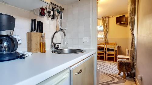 une cuisine avec un évier et un micro-ondes dans l'établissement Nabor 4 - appartement - 4 pers - centre, aux Gets