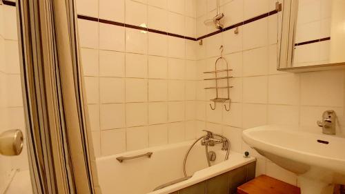une salle de bain avec une baignoire et un lavabo dans l'établissement Nabor 4 - appartement - 4 pers - centre, aux Gets