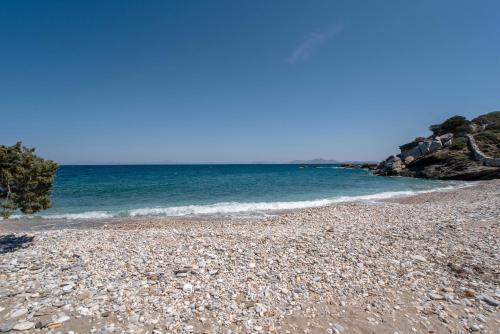 a rocky beach with the ocean in the background at Black Sand in Moutsouna Naxos