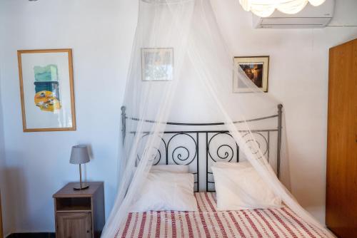 a bedroom with a bed with a canopy at Black Sand in Moutsouna Naxos