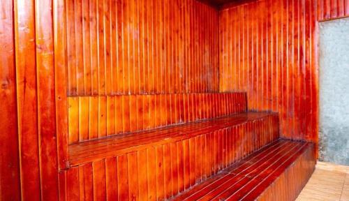 a wooden wall with a wooden bench in a room at Airport Shoebill Hotel in Entebbe