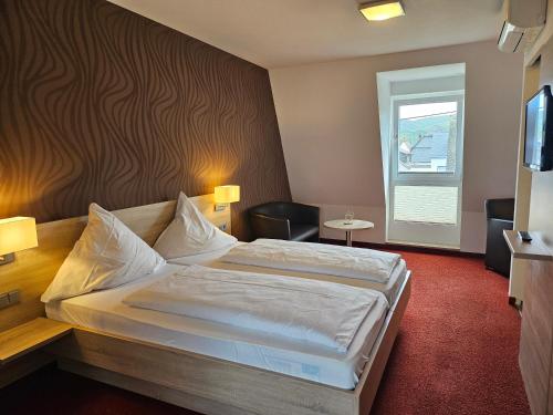 a hotel room with a large bed and a window at Lindenhof in Osterspai