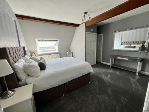 a bedroom with a bed and a desk and a window at The Loft @ Brighouse in Brighouse