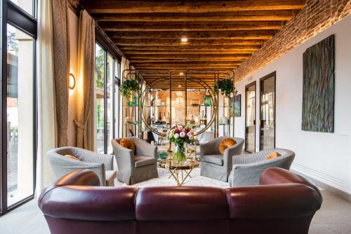 a living room with a leather couch and chairs at Hotel Ristorante Magia del Brenta in Fiesso dʼArtico