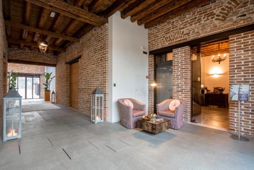 a living room with two chairs and a brick wall at Hotel Ristorante Magia del Brenta in Fiesso dʼArtico
