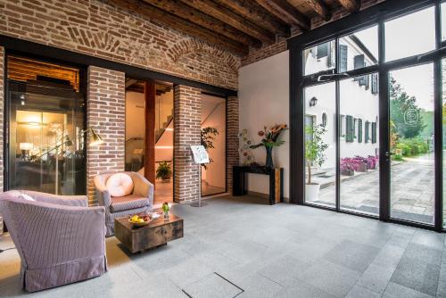 a living room with a brick wall at Hotel Ristorante Magia del Brenta in Fiesso dʼArtico