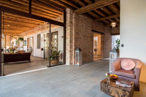a living room with a brick wall and a couch at Hotel Ristorante Magia del Brenta in Fiesso dʼArtico