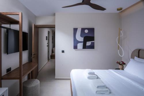 a bedroom with a bed and a ceiling fan at VAYA Suites by Omilos Hotels in Amoudara Herakliou