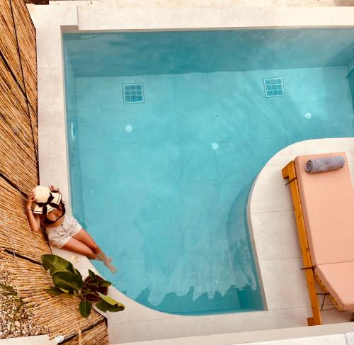 a small child in a swimming pool next to a pool at Amo Golden Suites in Chrysi Ammoudia